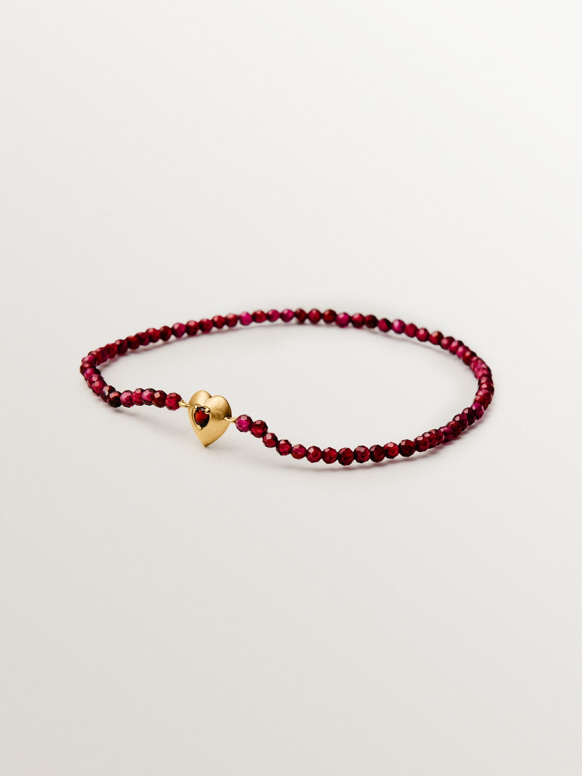 Pulsera de plata bañada en oro amarillo de 18K con cuentas de granates y forma de corazón
